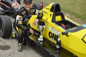 kaylen frederick | pilot one racing | kaylen with trophies on car